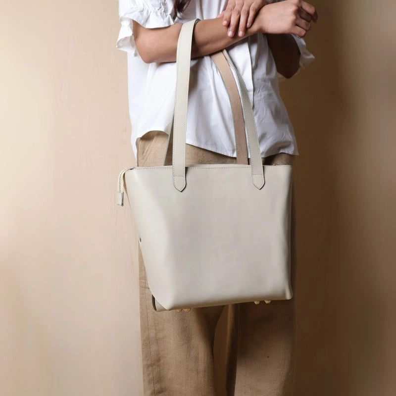 Woman carrying a White leather tote bag in her arms