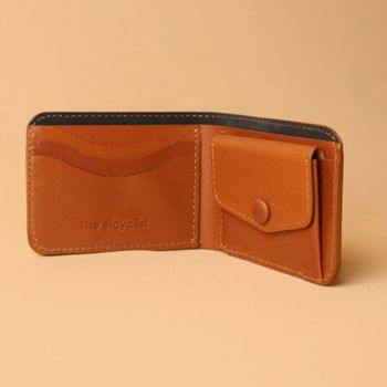 Brown leather wallet with visible brand logo on a beige background