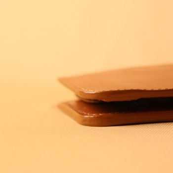Close-up of a Tan brown leather bifold wallet on a beige background
