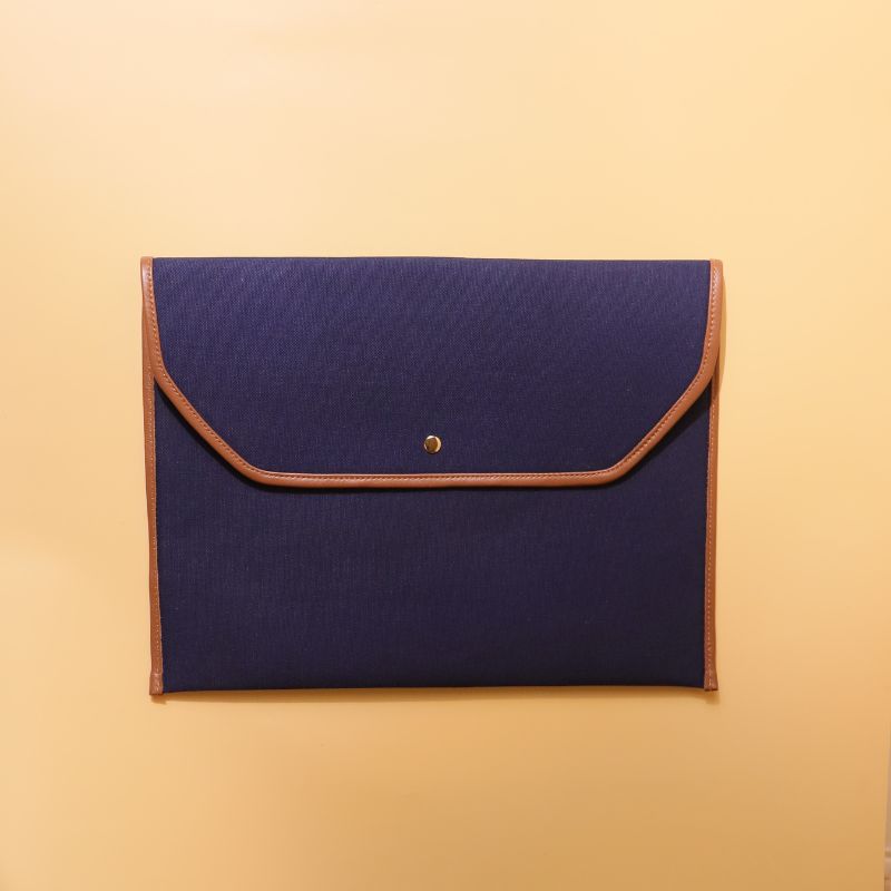 Document holder and laptop sleeve in Canvas with leather trims-Deep Blue Canvas with tan leather trim-gold plated metal snap button-beige felt lining-front view-The Bicyclist