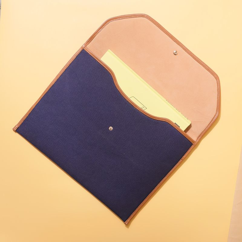 Document holder and laptop sleeve in Canvas with leather trims-Deep Blue Canvas with tan leather trim-gold plated metal snap button-beige felt lining-front top open view-The Bicyclist