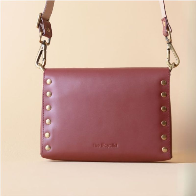 Back View of a Leather Side Sling bag in Maroon with light gold studs