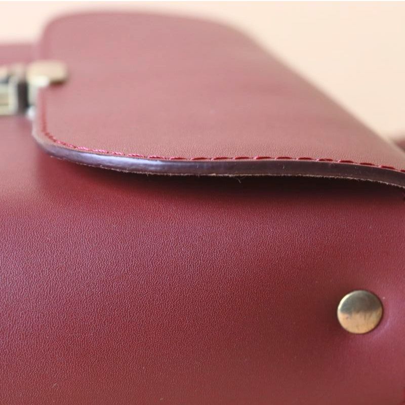 Detailed edge Finishing view of a maroon leather crossbody sling bag