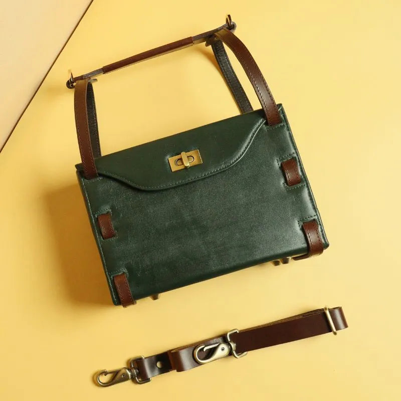 Top image of a dark green leather structured crossbody sling hand bag with removable dark brown leather straps, dark brown leather handle and a light gold twist lock