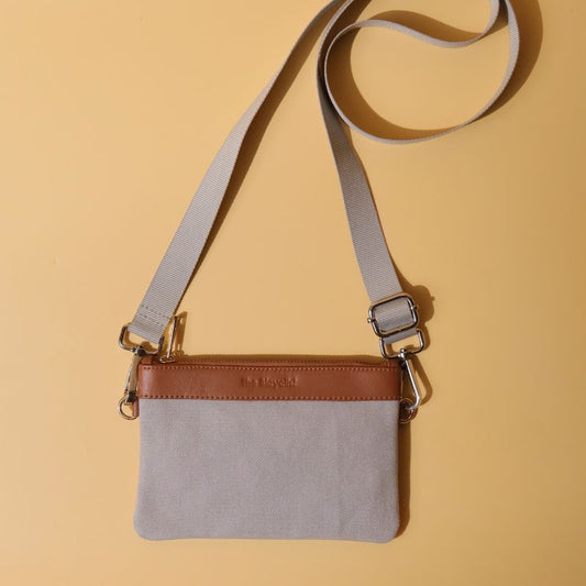 Canvas and Leather Compact Pouch Sling Bag-Light Grey Canvas and tan leather-gold plated metal hook-top front angle with strap-The Bicyclist