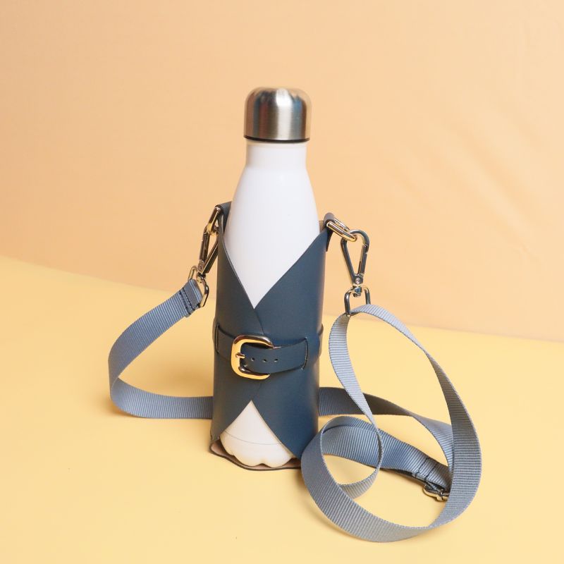 Leather Bottle Holder Sling Carrier-deep blue leather straps-gold plated metal hook-front standing angle view-The Bicyclist