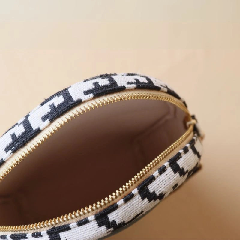 Internal view of Canvas Sling bag with gold metal zip in a black and white houndstooth weave