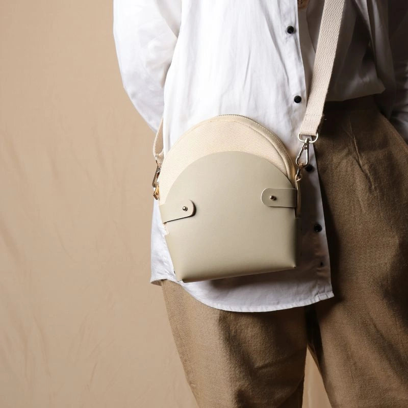 Woman In a white shirt carrying a off-white canvas crossbody shoulder sling in a 0ff-White Leather Case