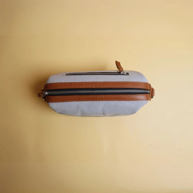 Top Closed view of a grey cotton canvas and tan leather dopp kit with metal zip