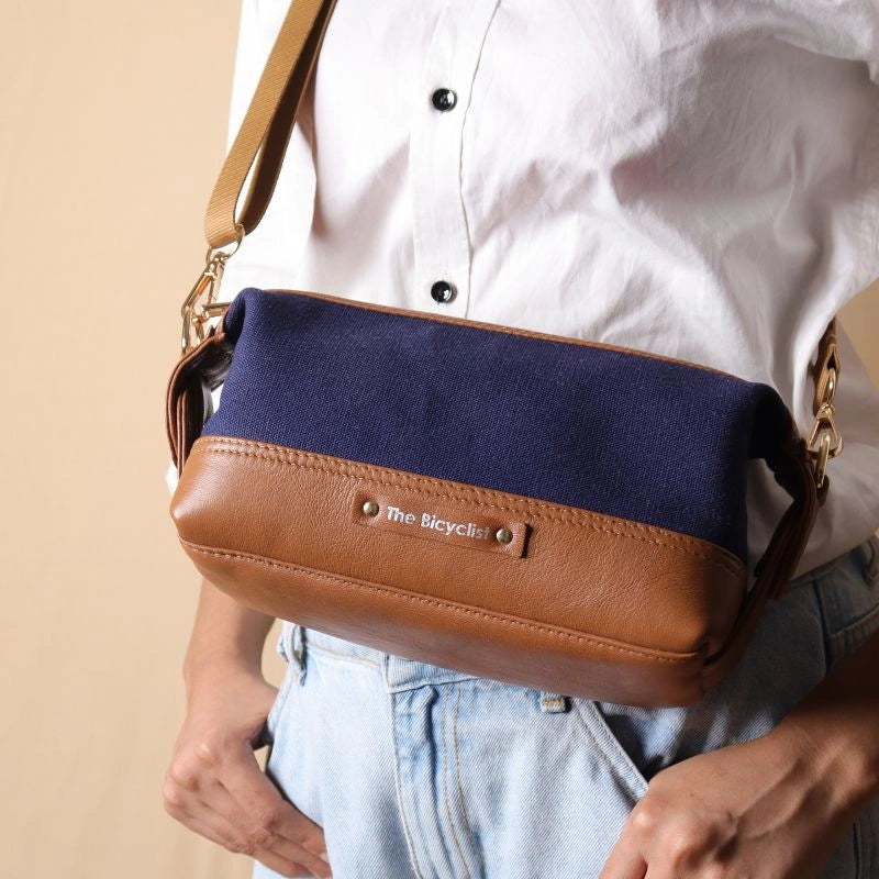 Front View Woman in a white shirt carrying a Navy Blue canvas and tan leather pouch as a side sling across her shoulder