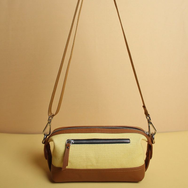 Yellow Canvas and Tan Sheep Leather Cosmetics Pouch Dopp Kit for women with Removable and Adjustable Sling straps a metal zip closure with a zipped pocket on the outside and chrome plated fittings back standing view with sling