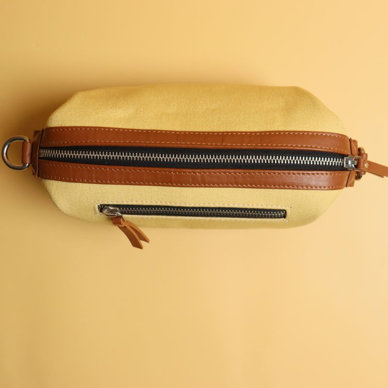 Yellow Canvas and Tan Sheep Leather Cosmetics Pouch Dopp Kit for women with Removable and Adjustable Sling straps a metal zip closure with a zipped pocket on the outside and chrome plated fittings top closed view