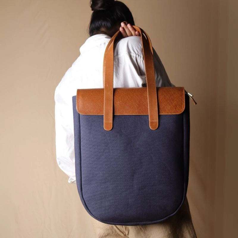 Woman in white shirt carrying a Deep Blue Tote bag with Tan Leather Flap and Tan Leather Straps over her shoulders