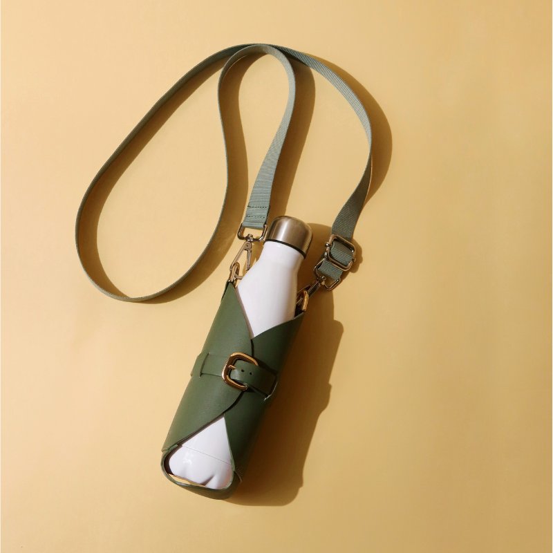 Leather one liter bottle carrier case in Dark Green with chrome plated finish metal fittings and a removable and adjustable nylon strap along with a white bottle front top image with sling attached