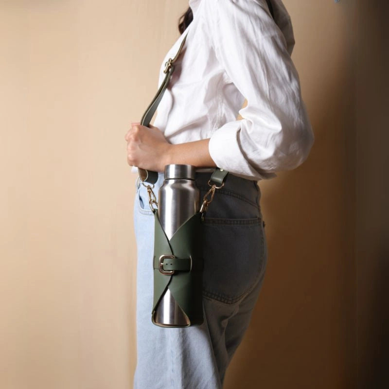 Woman carrying an adjustable leather bottle carrier with a stainless steel bottle
