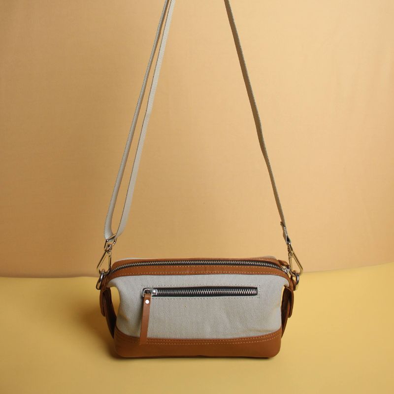 Grey Canvas and Tan Sheep Leather Shaving Pouch Dopp Kit with Removable and Adjustable Sling straps a metal zip closure with a zipped pocket on the outside and chrome plated fittings standing view