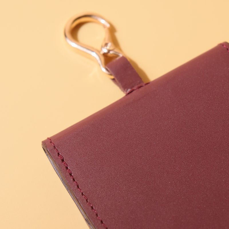 Vanity Mirror in a Deep Red Leather Casing with a Gold finished Metal Hook and a Gold Snap Button Detailed View