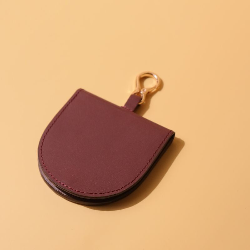 Vanity Mirror in a Deep Red Leather Casing with a Gold finished Metal Hook and a Gold Snap Button Closed top View