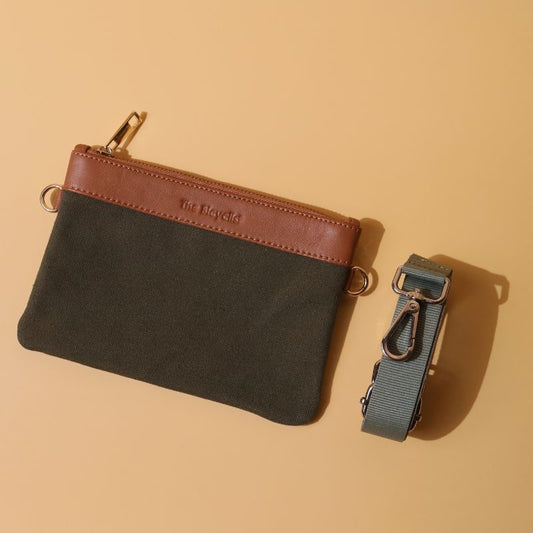 A mini  pouch with removable straps in dark green canvas and tan sheep leather with metal fittings in plated chrome finish