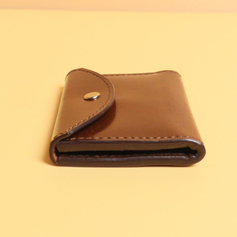Dark Brown Bifold Leather Wallet with a Flap  Closure with a metal Snap Button in Gold Metal Finish and Three Card pockets with two cards in each pocket and one cash pocket  with a tan sheep leather lining detail side view