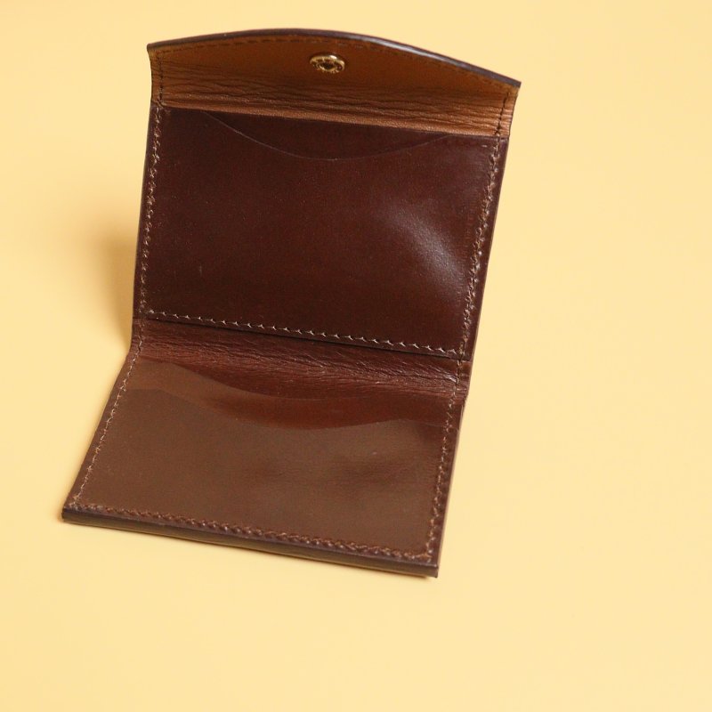 Dark Brown Bifold Leather Wallet with a Flap  Closure with a metal Snap Button in Gold Metal Finish and Three Card pockets with two cards in each pocket and one cash pocket  with a tan sheep leather lining open view
