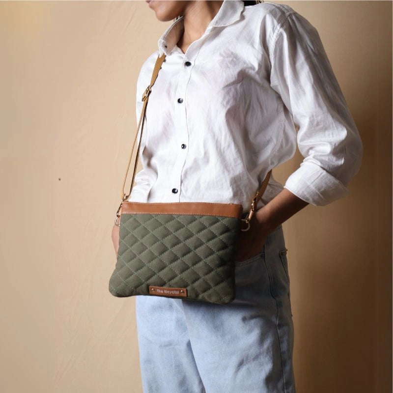 Woman in white shirt carrying a quilted cotton canvas crossbody sling bag in dark green around her shoulder