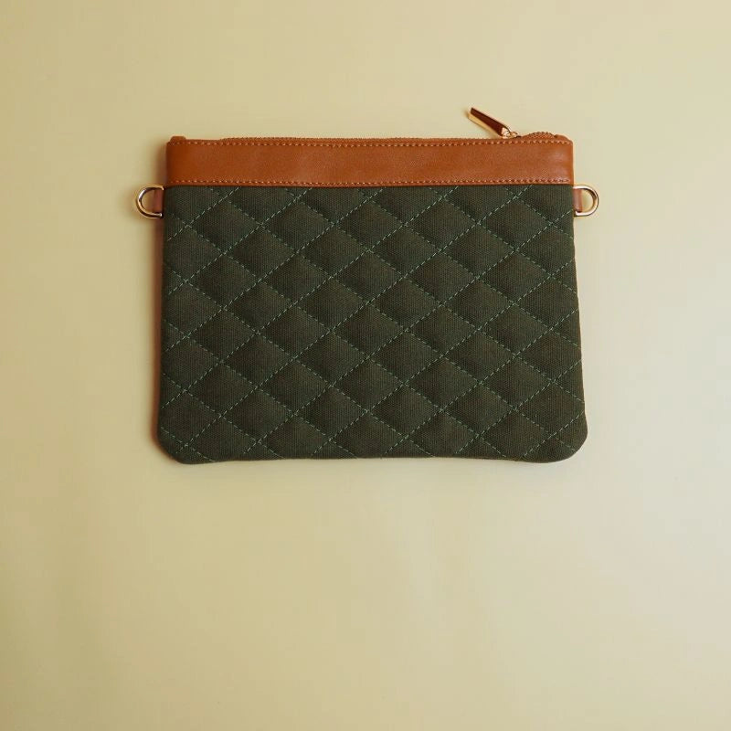 Back view of a dark green cotton canvas pouch bag with leather trim and a zip closure