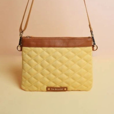 Upright View of a Quilted yellow Canvas and tan leather crossbody sling bag
