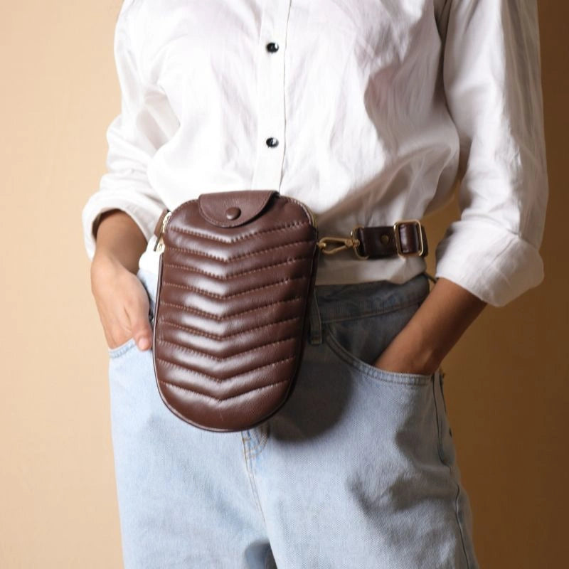 Woman in a white shirt wearing a dark brown leather quilted pouch bag around her waist