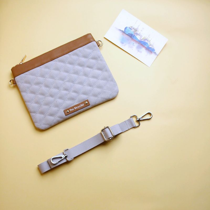 Small Crossbody Sling Pouch for Women with a Quilted gray Canvas and Tan Sheep Leather Trimming with a Zip Closure removable and adjustable straps in chrome plated finish flat top view