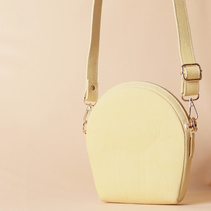 Hancrafted Canvas and Leather slingbag-yellow canvas body with off-white leather case cotton lining-adjustable and removable shoulder straps-gold plated metal fittings-canvas sling front angle view-The Bicyclist