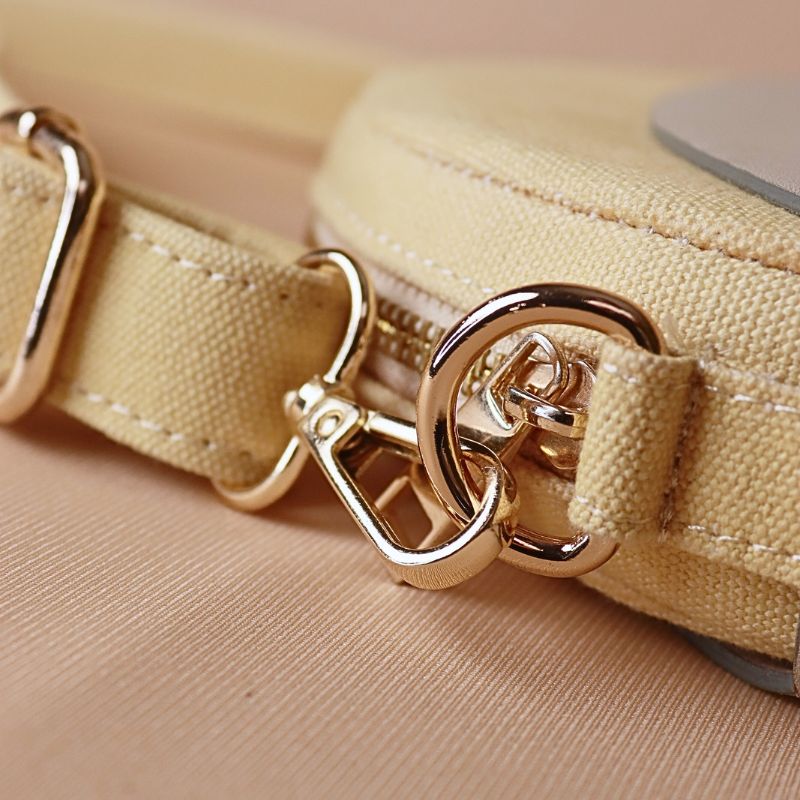 Hancrafted Canvas and Leather slingbag-yellow canvas body with off-white leather case cotton lining-adjustable and removable shoulder straps-gold plated metal fittings-canvas bag detail angle view-The Bicyclist