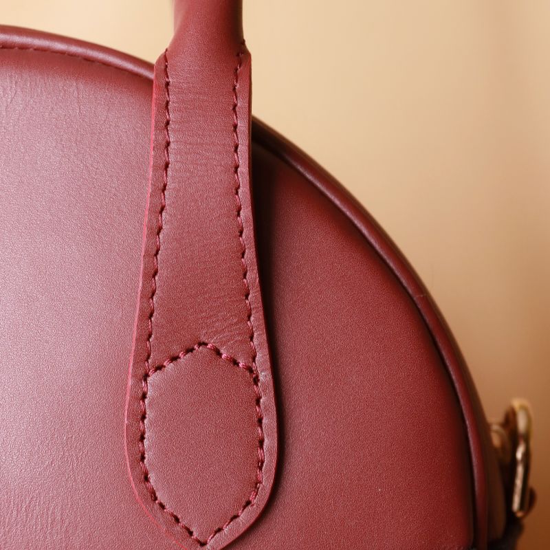 Hancrafted Canvas and Leather handbag-deep blue canvas body with maroon grain leather top-beige felt lining-adjustable and removable white shoulder straps-gold plated metal fittings-handle view-The Bicyclist