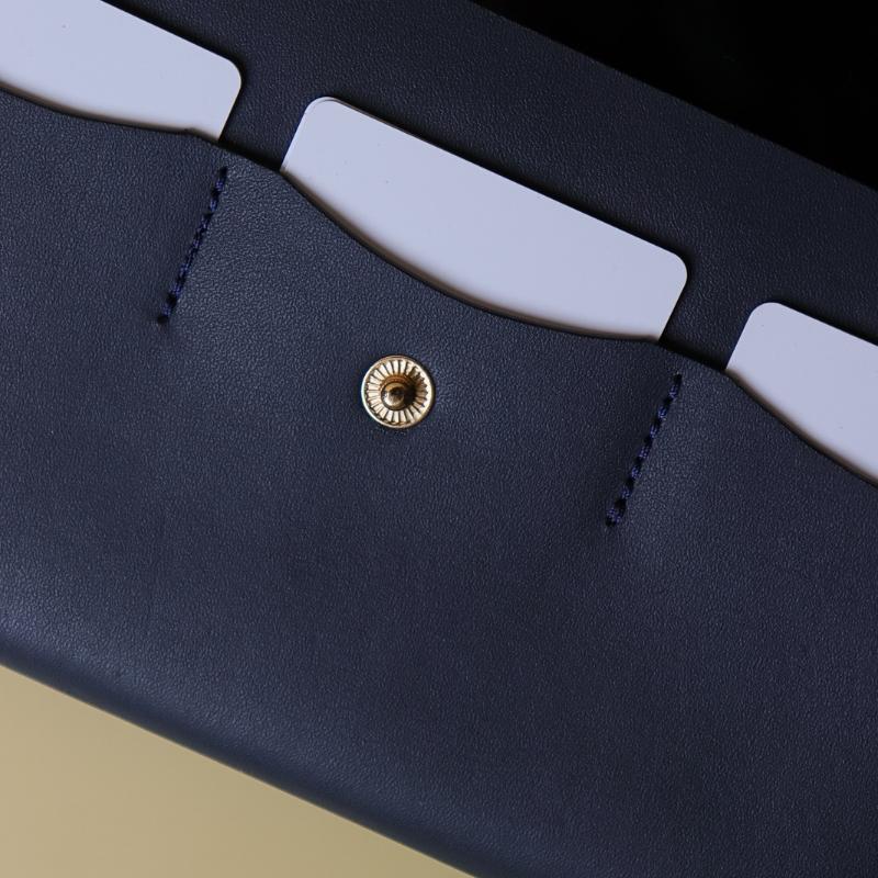 Detailed Stitching View of a Handmade Leather Wallet in Deep Blue with White Plastic Cards and a Golden Metal Snap Button