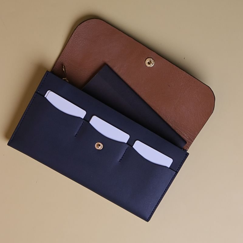 Open View of a Large Long Wallet for Women, handmade with Deep Blue Leather with an inner lining of light brown sheep leather with a small black notebook and three plastic cards