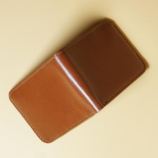 Tan Brown leather wallet on a beige background top view