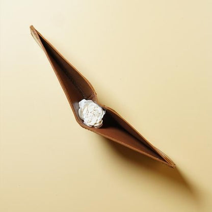 Tan Brown leather wallet with a white rose on a beige background