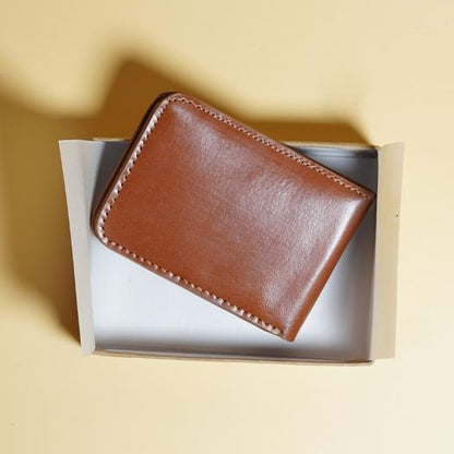 Tan Brown leather wallet in a box on a yellow background