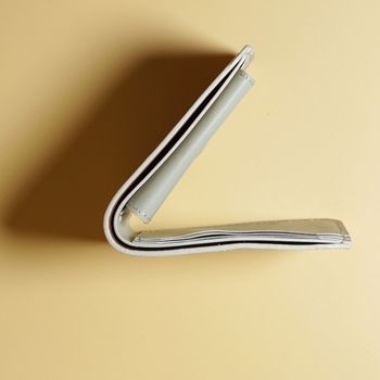 Top view of a off White bifold leather wallet on a beige background