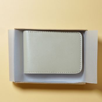 Off White leather wallet in an open box on a beige background