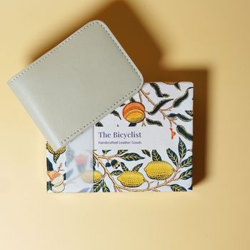 Off White bifold leather wallet with a botanical design card on a beige background