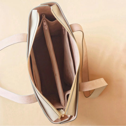 Top Open View of a White Leather Tote Bag on a light peach background