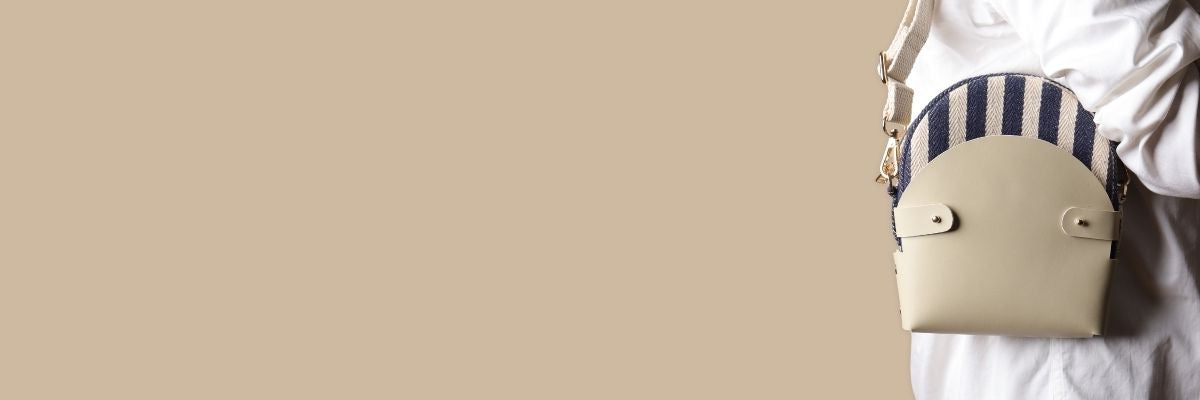 Beige handbag with striped pattern on a beige background