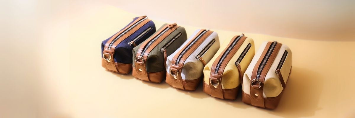 Five small pouches with zippers in various colors on a beige background