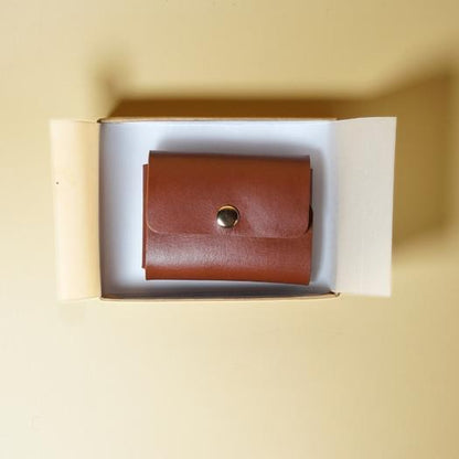 Tan Brown leather wallet in an open box on a beige background