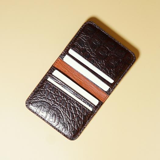 Maroon color crocodile textured leather with tan leather lining on a beige background