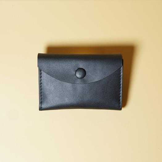 Black leather wallet on a beige background