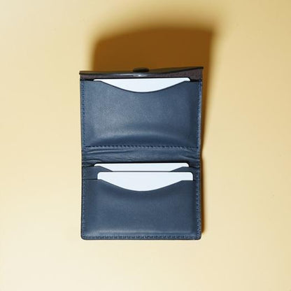 Blue leather wallet with card slots on a beige background
