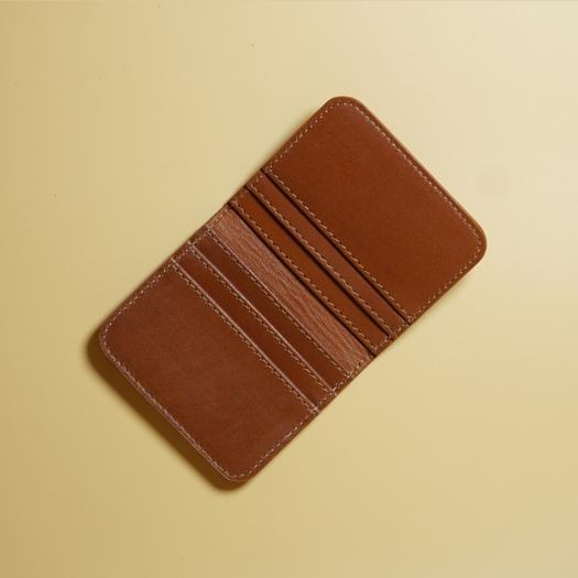 Tan Brown leather wallet on a beige background