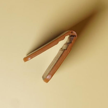 Edge of a tan brown leather wallet on a beige background